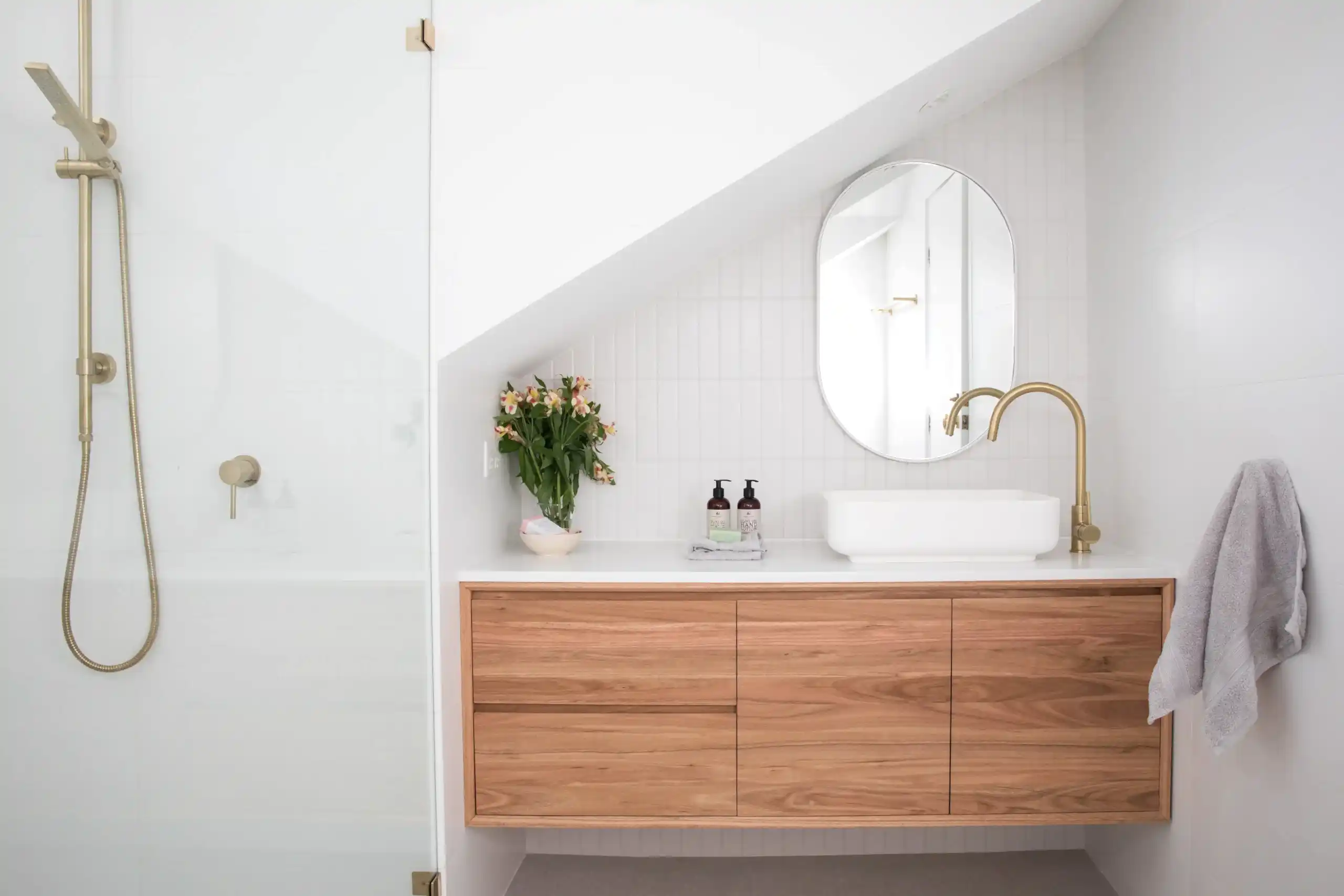 Tezgah üstü lavabo, ahşap asma banyo dolabı ve gold batarya ile modern banyo tasarımı